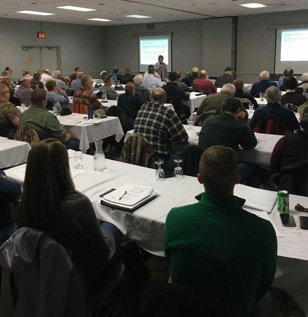 A meeting space at Treetops Resort with white tablecloths and engaged attendees.